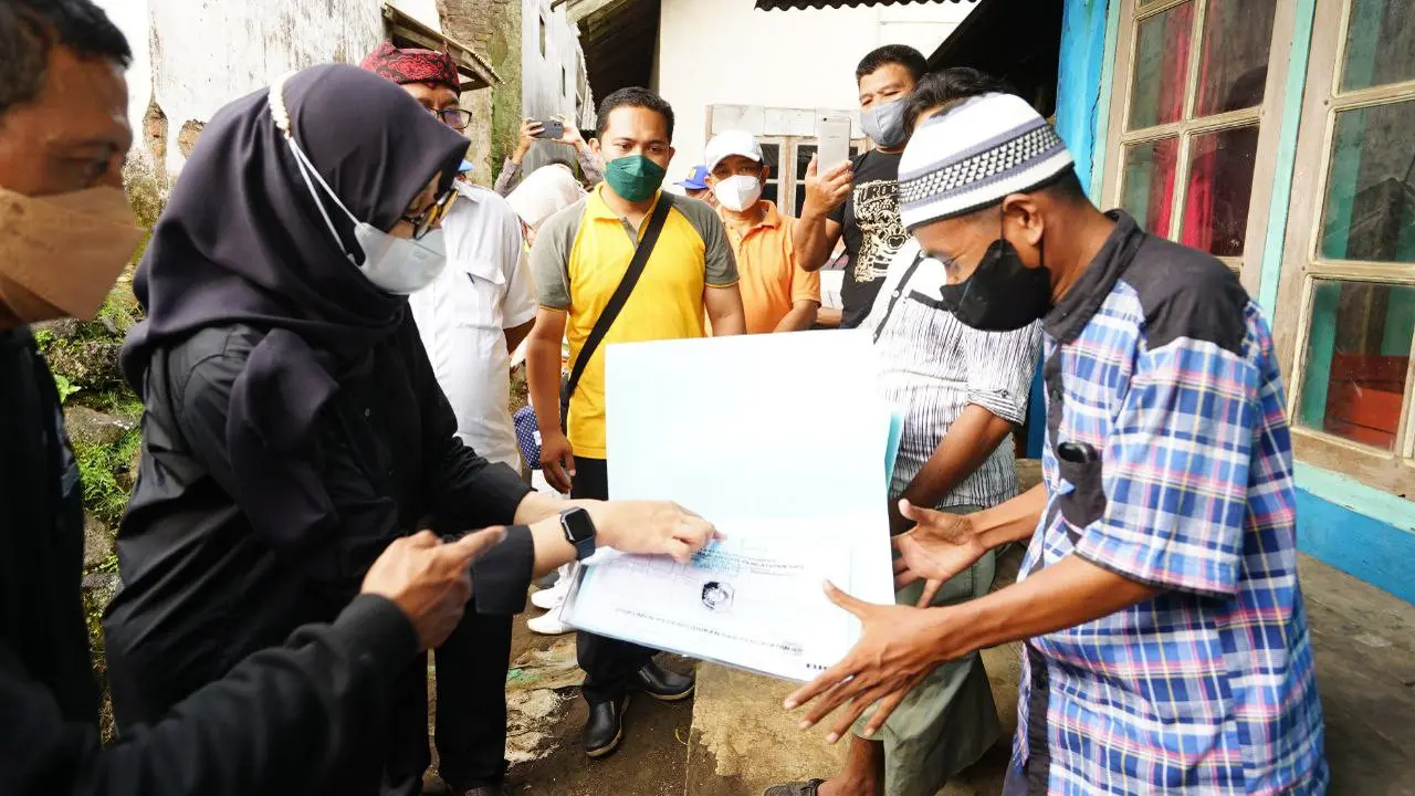 Bupati Banyuwangi Ipuk Fiestiandani menyerahkan dokumen kependudukan kepada warga perkebunan Jatirono Kalibaru. (Istimewa)