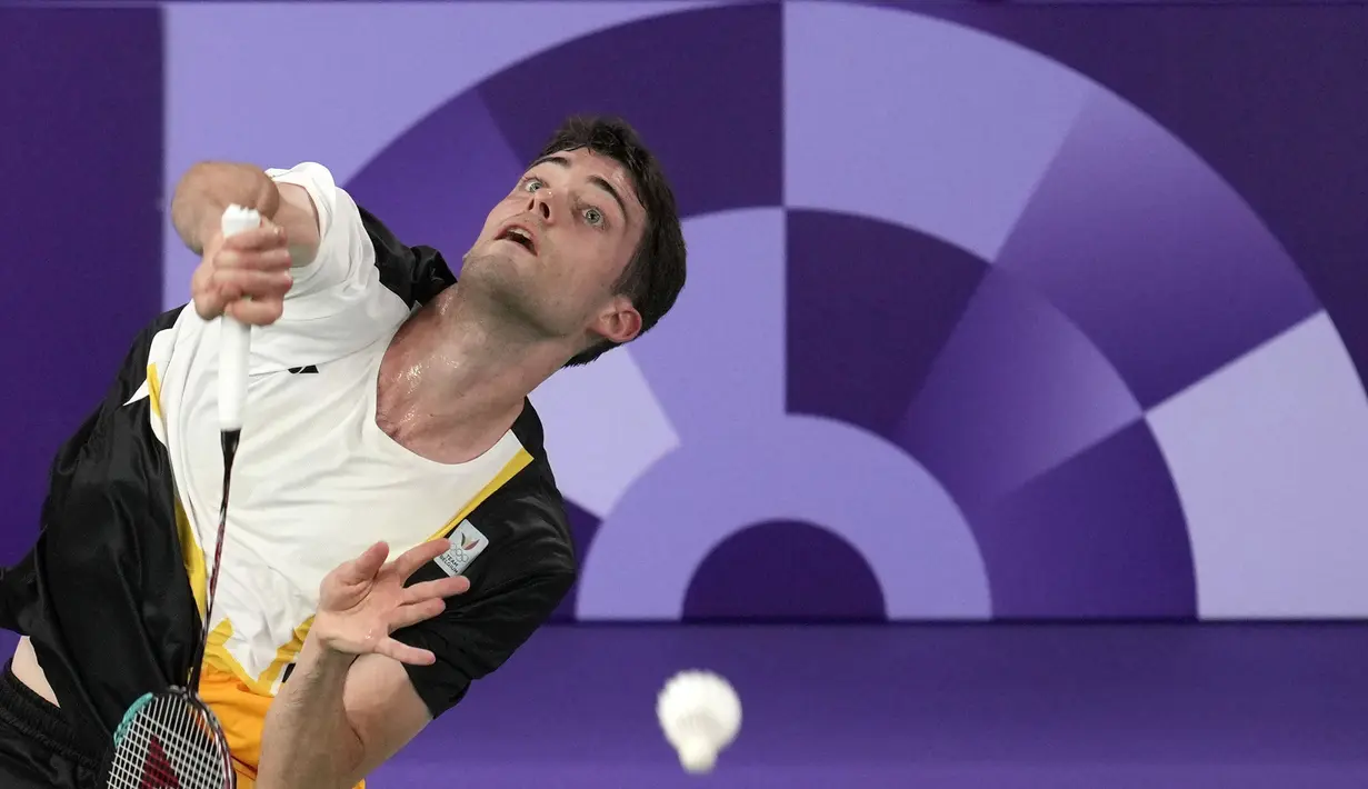 Pebulu tangkis tunggal putra Belgia, Julien Carraggi memukul kok ke arah pebulu tangkis Indonesia, Jonatan Christie pada laga Grup A cabang olahraga bulu tangkis Olimpiade Paris 2024 di Porte de la Chapelle Arena, Paris, Prancis, Sabtu (27/07/2024). (AP Photo/Kin Cheung)