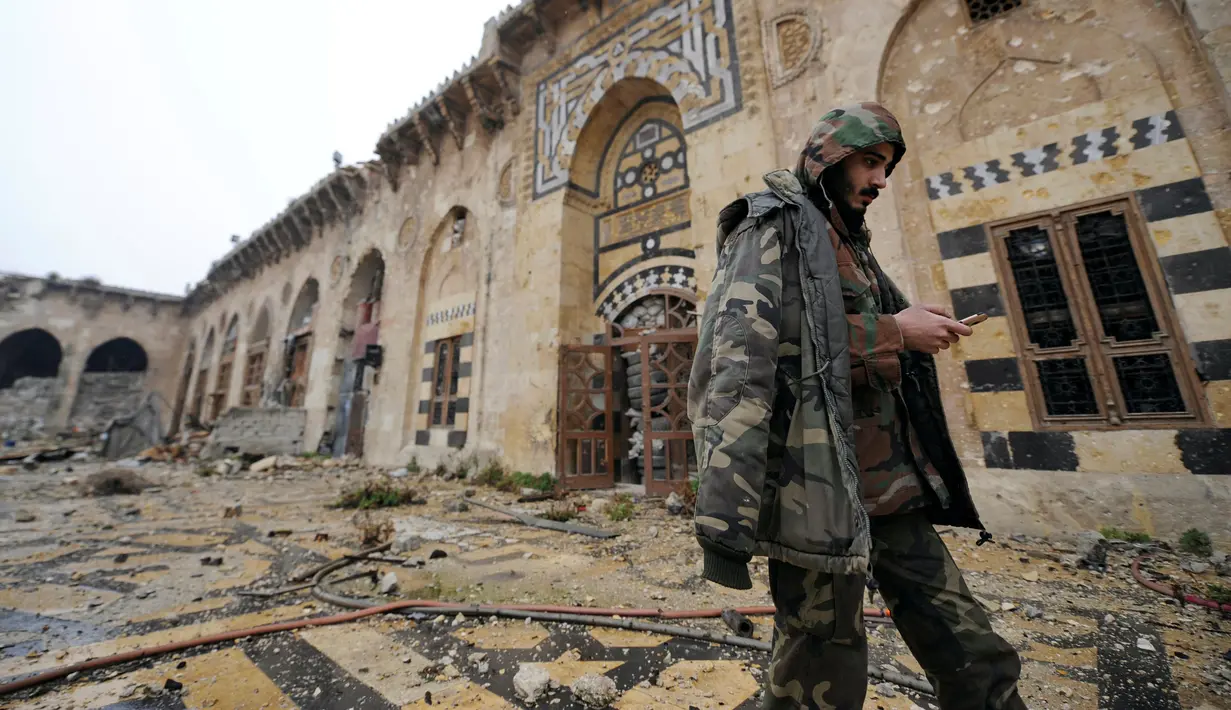 Anggota pasukan Presiden Suriah Bashar al-Assad berjalan di antara puing reruntuhan bangunan di kompleks Masjid Umayyad, Aleppo di Suriah, 13 Desember 2016. Konflik antara pemerintah dan pemberontak membuat masjid tersebut hancur. (REUTERS/Omar Sanadiki)