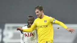 Pemain Fulham Joachim Andersen (kanan) berebut bola dengan pemain Tottenham Hotspur Tanguy Ndombele pada pertandingan Liga Inggris di Stadion Tottenham Hotspur, London, Inggris, Rabu (13/1/2021). Pertandingan berakhir dengan skor 1-1. (Glyn Kirk / Pool via AP)