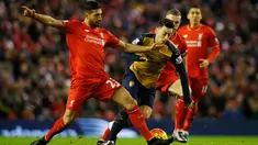 Gelandang Arsenal, Mesut Ozil berusaha melewati gelandang Liverpool, Emre Can pada pada lanjutan Liga Inggris di stadion Anfield, Inggris (14/1/2016). Liverpool bermain imbang dengan Arsenal dengan skor 3-3. (Reuters/Phil Noble)