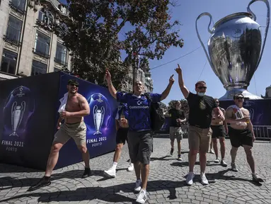 Suporter Chelsea berjalan melewati replika raksasa trofi Liga Champions di pusat kota Porto, Portugal (28/5/2021). Klub Inggris Manchester City dan Chelsea akan memainkan final Liga Champions di stadion Dragao di Porto pada Sabtu malam atau Minggu (30/5/2021) dini hari. (AP Photo/Luis Vieira)