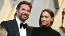 Aktor Bradley Cooper dan pasangannya, Irina Shayk  menghadiri perhelatan Oscar 2019 di Dolby Theatre, Los Angeles, Minggu (24/2). Bradley Cooper yang juga mengajak sang ibu tampil kompak dengan busana serba hitam. (Jordan Strauss/Invision/AP)