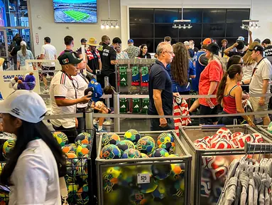 Ratusan suporter memadati FIFA Store di MetLife Stadium, East Rutherford, New Jersey, Amerika Serikat, untuk berburu merchandise resmi Piala Dunia 2026 menjelang laga fase grup Prancis melawan Senegal. Berbagai produk seperti bola resmi pertandingan, jersey, syal, hingga aksesori tim nasional menjadi incaran para penggemar dari berbagai negara. Antusiasme tinggi membuat area toko dipenuhi pengunjung yang rela mengantre demi mendapatkan suvenir resmi turnamen. (KLY Sports/Hery Kurniawan)
