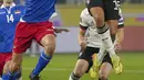 Penyerang timnas Jerman Lukas Nmecha menyundul bola saat bersaing dengan bek Liechtenstein Rafael Gruenenfelder dalam Kualifikasi Piala Dunia 2022 Zona Eropa di Volskwagen Arena, Jumat (12/11/2021) dinihari WIB. Jerman menang 9-0 atas tamunya Liechtenstein. (AP Photo/Michael Sohn)