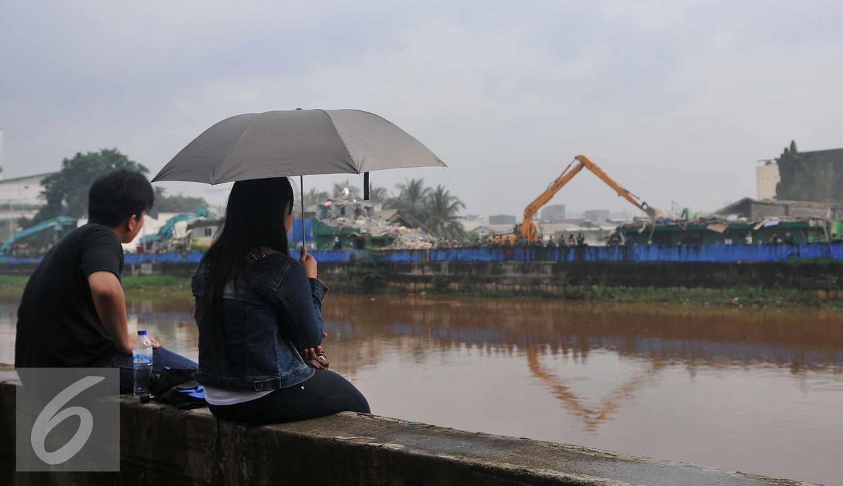 Warga menyaksikan pembokaran bangunan di kawasan prostitusi Kalijodo, Jakarta Utara, Senin (29/2). Puluhan bangunan di kawasan tersebut mulai rata dengan tanah serta menjadi tontonan warga. (Liputan6.com/Gempur M Surya)