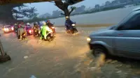 Pengguna jalan nekad menembus derasnya arus air di jalan Tambak Besar. (foto: Liputan6.com/felek wahyu)