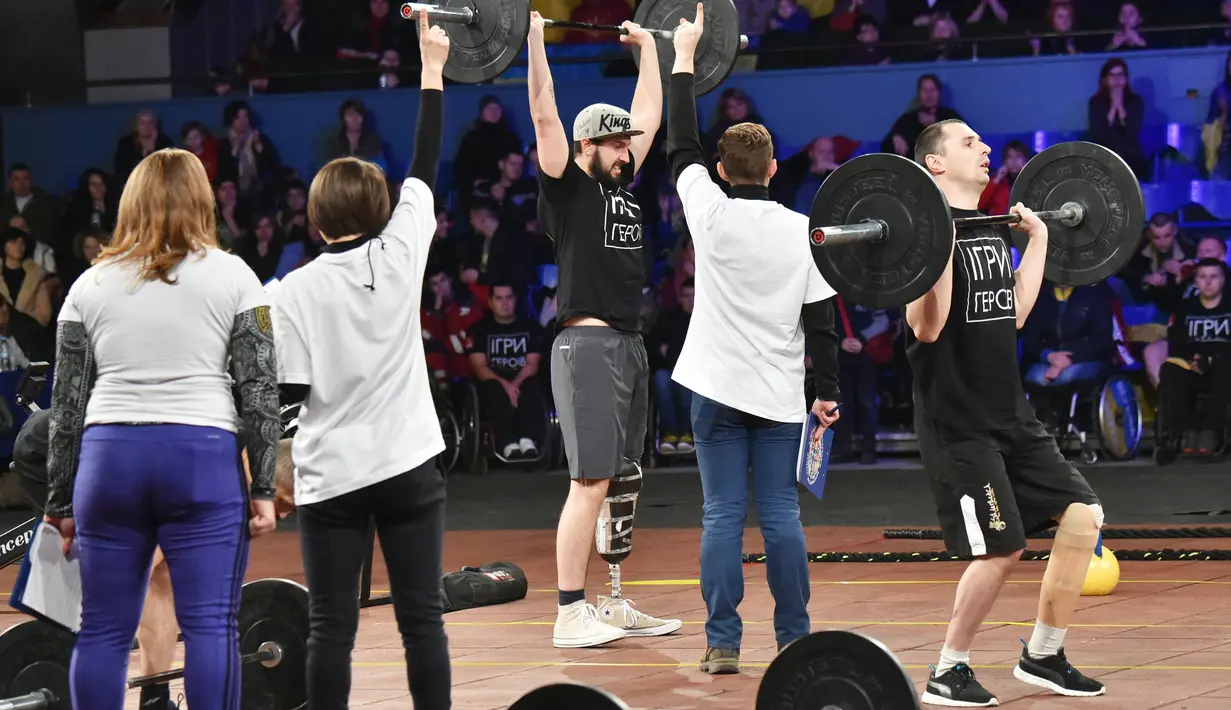 Para peserta mengangkat beban saat kompetisi final CrossFit "Game of Heroes" di Kiev, Ukraina (24/12). CrossFit ini adalah metode kebugaran fungsional seluruh tubuh, yang biasanya dipakai oleh marinir AS, tim olahraga profesional. (AFP/Sergei Supinsky)