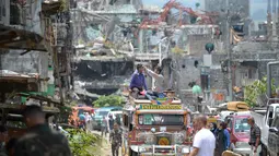 Warga mengambil gambar bangunan yang hancur dari atas mobil saat memasuki Kota Marawi, Mindanao, Filipina, Minggu (1/4). Mereka hampir setahun mengungki akibat pertempuran militer Filipina dengan militan ISIS. (TED ALJIBE/AFP)