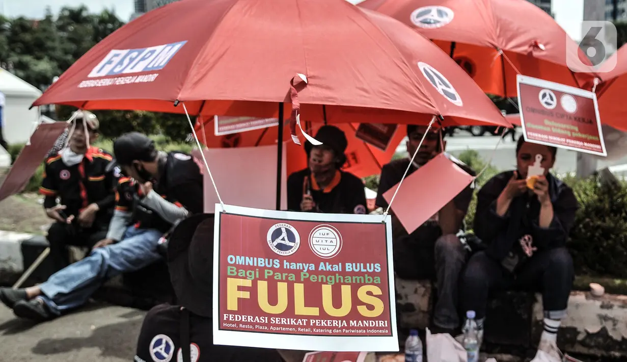 Poster tuntutan yang dibawa masa buruh dalam aksi di kawasan Patung Kuda, Jakarta, Senin (2/11/2020). Massa buruh dari berbagai serikat pekerja tersebut menggelar demo terkait penolakan pengesahan omnibus law Undang-Undang Cipta Kerja dan upah minimum 2021. (merdeka.com/Iqbal S Nugroho)