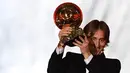 Gelandang Real Madrid, Luka Modric mengangkat trofi setelah memenangkan penghargaan Ballon d'Or 2018 di Grand Palais, Paris, Senin (3/12). Modric sukses memutus dominasi Cristiano Ronaldo dan Lionel Messi yang bertahan selama satu dekade (FRANCK FIFE/AFP)