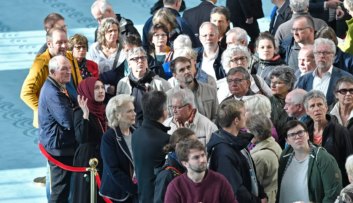 Para pengunjung berkumpul di salah satu sudut dalam Masjid Cologne saat berkunjung pada Hari Masjid Terbuka di Cologne, Jerman, Selasa (3/10). Ribuan masjid dibuka untuk umum termasuk non muslim untuk berkunjung ke dalamnya. (AP Photo/Martin Meissner)
