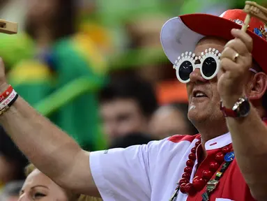 Seorang pria menggunakan atribut unik saat menyaksikan pertandingan bola tangan antara Polandia vs Brasil dalam ajang Olimpiade 2016, di Rio de Janeiro, 10 Agustus 2016. (AFP PHOTO/Franck FIFE)