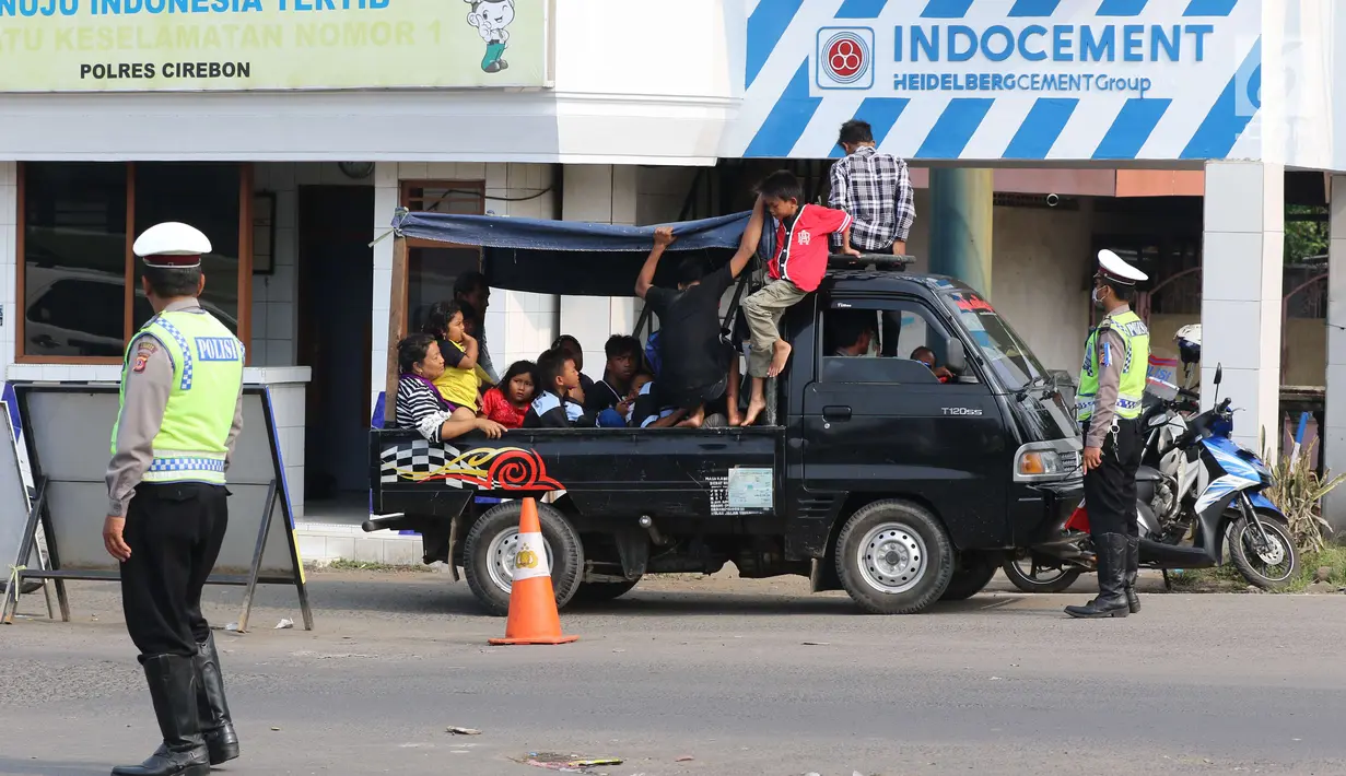 Polisi memberhentikan mobil saat mengatur lalu lintas di Pos Palimanan Cirebon, Jawa Barat, Jumat (30/6). (Liputan6.com/Helmi Afandi) 