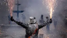 Peserta memegang petasan saat mengikuti festival Els Enfarinats di kota Ibi dekat Alicante, Spanyol (28/12). Selama sekitar 200 tahun penduduk Ibi setiap tahun merayakan dengan pertempuran menggunakan tepung, telur, dan petasan. (AP Photo/Alberto Saiz)