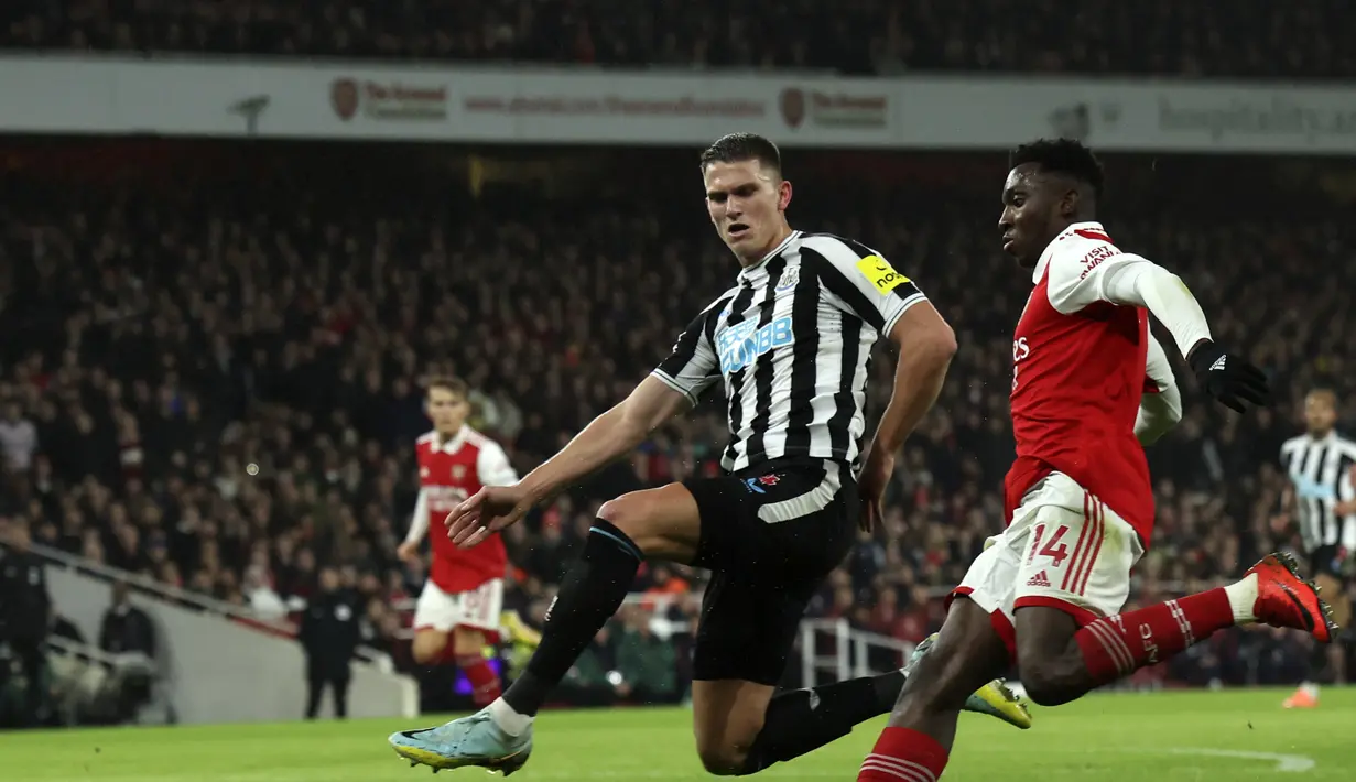 Bek Newcastle United, Sven Botman mencoba untuk memblokir tembakan dari penyerang Arsenal, Eddie Nketiah selama pertandingan lanjutan Liga Inggris di stadion Emirates di London, Rabu (4/1/2023). Hasil ini membuat Arsenal kini mengumpulkan 44 poin di puncak klasemen dan Newcastle berada di posisi ketiga dengan 35 poin. (AP Photo/Ian Walton)