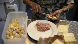 Nenek Leong Yuet Meng, pemilik usaha Nam Seng Noodle House membungkus isian daging ke dalam pangsit di warungnya di Singapura (22/3). Nenek Leong disebut sebagai salah satu pedagang makanan tertua di Asia dan bahkan mungkin dunia. (Reuters/Edgar Su)