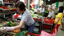 Nenek Leong Yuet Meng berbelanja  bahan-bahan yang dibutuhkan untuk membuat mie pangsit di pasar di Singapura (22/3). Nenek Leong selalu diantar putranya saat belanja ke pasar. (Reuters/Edgar Su)
