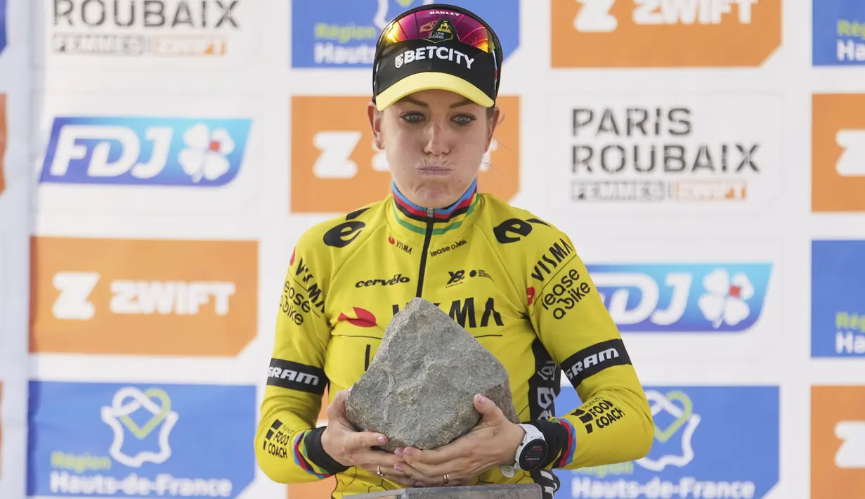 Ekspresi keberatan pembalap Team Visma-Lease, Pauline Ferrand-Prevot saat menjunjung trofi kemenangan Paris Roubaix Femmes 2025 pada Sabtu (12/04/2025) waktu setempat. Perlombaan tersebut menempuh 148,5 km dari Denain hingga Roubaix, Prancis. (AP Photo/Thibault Camus)