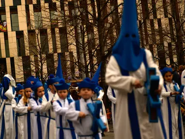 Peniten bertopeng menyusuri jalan dalam prosesi Minggu Palma di Zaragoza, Spanyol, Minggu (25/3). Minggu Palma dirayakan menjelang Paskah. (Foto AP/Alvaro Barrientos)