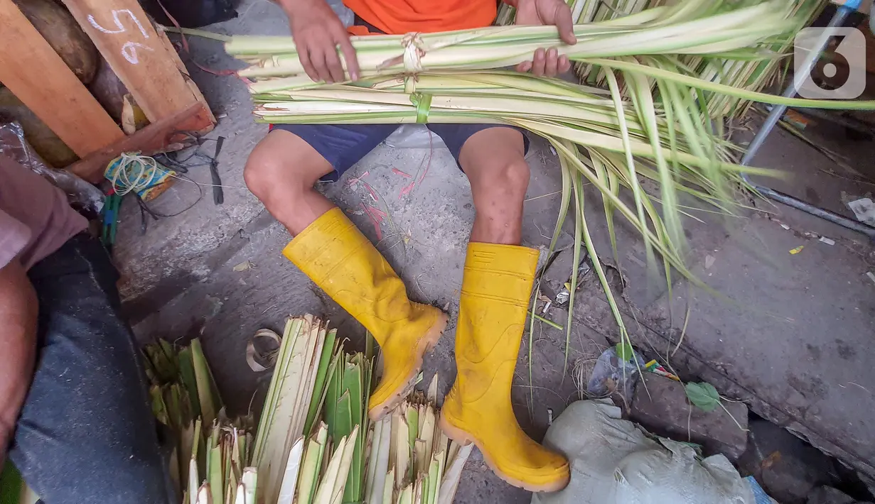 Pedagang membuat kulit ketupat dari anyaman daun kelapa muda (janur) di Pasar Pondok Labu, Jakarta Selatan, Kamis (30/7/2020). Pedagang musiman kulit ketupat yang sebagian datang dari Serang, Banten mulai ramai memadati kawasan Pasar Pondok Labu. (Liputan6.com/Fery Pradolo)