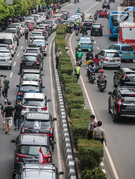 Kendaraan melintas dekat mobil pengemudi online yang menutup jalur lambat saat demonstrasi di kantor pusat Grab kawasan Kuningan, Jakarta, Senin (29/10). Aksi tersebut menyebabkan kemacaten dari arah Mampang menuju Menteng. (Liputan6.com/Faizal Fanani)