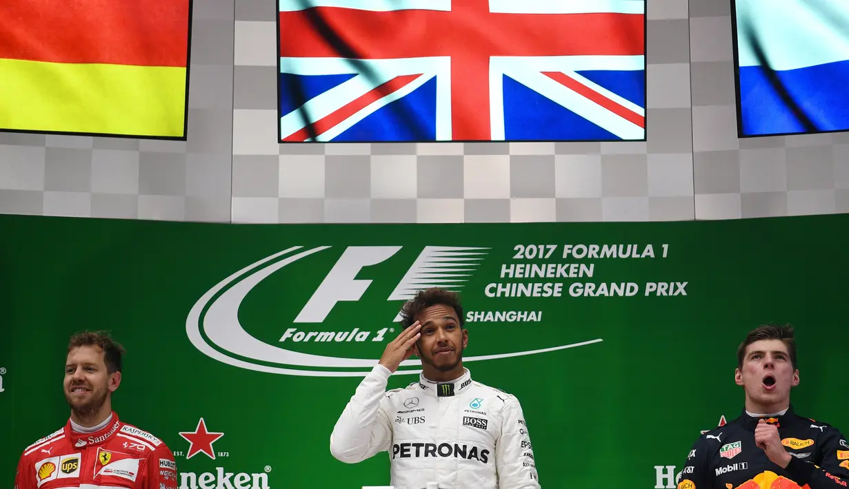Pembalap Mercedes Lewis Hamilton sebagai juara GP China, dan pembalap Ferrari Sebastian Vettel sebagai runner up serta pembalap Red Bull Max Verstappen sebagai juara ketiga di atas podium Sirkuit Internasional Shanghai, Minggu (9/4). (Johannes EISELE/AFP)