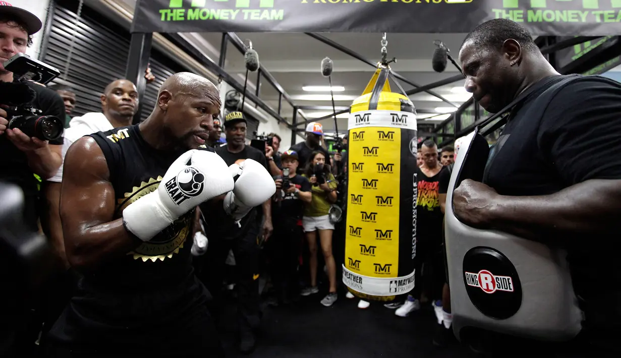 Petinju Floyd Mayweather Jr melakukan latihan didampingi pelatihnya di Mayweather Boxing Club, Las Vegas, Nevada (10/8). (AFP Photo/John Gurzinski)