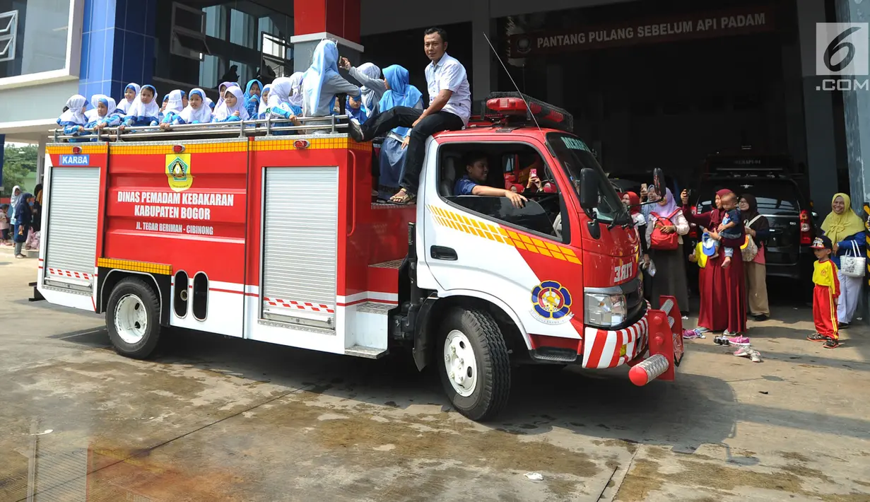 Sejumlah siswa TK di lingkungan Kabupaten Bogor menaiki mobil pemadam kebakaran saat berkunjung ke kantor Dinas Pemadam Kebakaran, Jalan Tegar beriman, Cibinong, Rabu (18/9/2019). Kegiatan belajar di luar kelas ini untuk mengenalkan profesi dan tugas pemadam kebakaran. (merdeka.com/Arie Basuki)