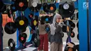 Pengunjung melihat-lihat laserdisc yang ada dalam acara Playfest 2019 di Parkir Selatan Gelora Bung Karno, Jakarta, Minggu (25/8/2019). Playfest 2019 mengusung konsep retro 90-an. (Liputan6.com/Faizal Fanani)