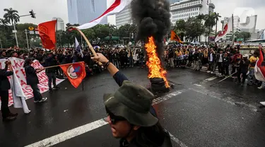 Sejumlah elemen mahasiswa membakar ban bekas saat menggelar demo di kawasan Patung Kuda, Jakarta Pusat (Jakpus), Kamis (8/9/2022). Aksi tersebut untuk menolak kenaikan harga Bahan Bakar Minyak (BBM). (Liputan6.com/Johan Tallo)