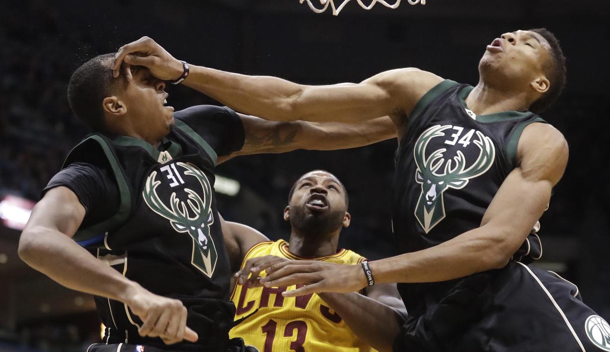 Pemain Milwaukee Bucks, Giannis Antetokounmpo (kanan) berbenturan dengan rekannya John Henson saat gagal menghadang tembakan pemain Cleveland Cavaliers,Tristan Thompson (tengah) pada laga NBA di BMO Harris Bradley Center (AP/Morry Gash)