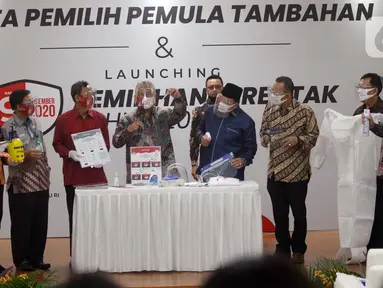 Ketua KPU Arief Budiman (tengah) bersama Wakil Ketua KPU Pramono Ubaid Tanthowi dan Anggota Bawaslu RI Mochammad Afifuddin saat memperlihatkan alat prosedur kesehatan dalam Launching Pemilihan Serentak Tahun 2020 di Gedung KPU RI, Menteng, Jakarta Pusat, Kamis (18/6/2020). (Liputan6.com/Johan Tallo)