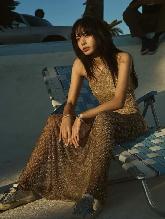 Kali ini ia juga kenakan dress off shoulder dengan nuansa emas berpadu sepatu sneakers yang begitu memikat.  [Foto: Instagram/ Elle USA]