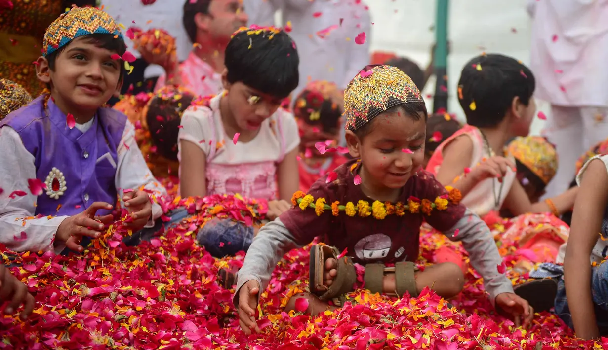 Anak-anak India bermain dengan kelopak bunga di sebuah acara untuk merayakan festival Hindu Holi untuk anak-anak cerebral palsy yang diselenggarakan oleh Yayasan Trishla di Allahabad (25/2). (AFP Photo/Sanjay Kanojia)