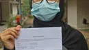 Pasien sembuh COVID-19 menunjukkan surat keterangan selesai isolasi di  Graha Wisata Ragunan di Jakarta, Jumat (29/1/2021). Data Satgas Covid-19 per Jumat (29/1), jumlah pasien yang sembuh bertambah 10.138 orang dengan total pasien sembuh mencapai 852.260 orang. (Liputan6.com/Herman Zakharia)