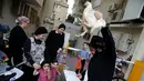 Sejumlah warga menyaksikan Pria Yahudi ultra-Ortodoks memegang ayam saat ia melakukan ritual Kaparot, di Bnei Brak, Israel, (9/10). (REUTERS/Baz Ratner)