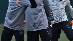 Pemain Liverpool, Georginio Wijnaldum, Roberto Firmino, Nathaniel Clyne melakukan pemanasan saat latihan di Melwood Training Ground, Liverpool, (5/3). Liverpool akan melawan Porto pada leg kedua babak 16 besar Liga Champions. (AFP Photo/Anthony Devlin)