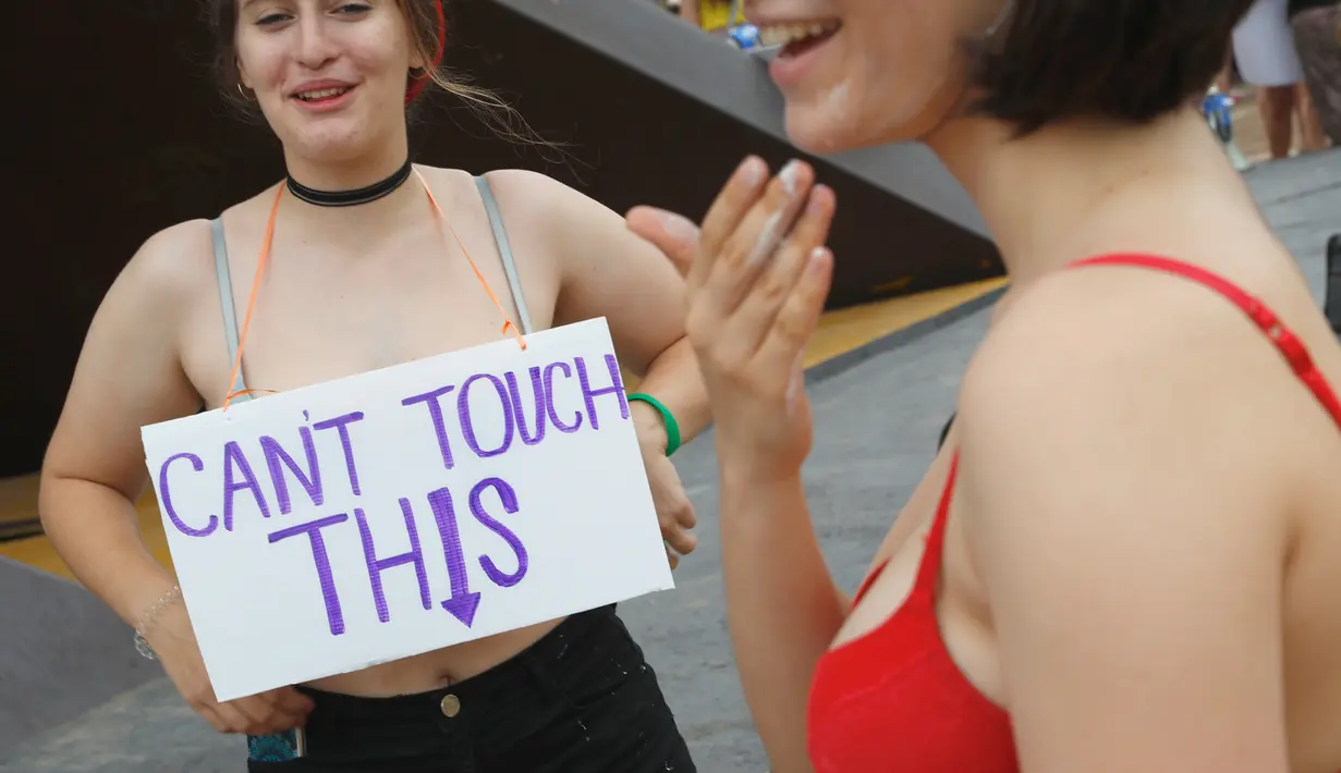 Dua wanita berunjuk rasa di pantai Mediterania Israel Tel Aviv (4/5). Protes ini terinspirasi kelompok wanita Kanada yang meluncurkan protes tahun 2011 sebagai tanggapan atas pertanyaan bahwa mereka ingin menghindari pelecehan. (AFP Photo/Jack Guez)