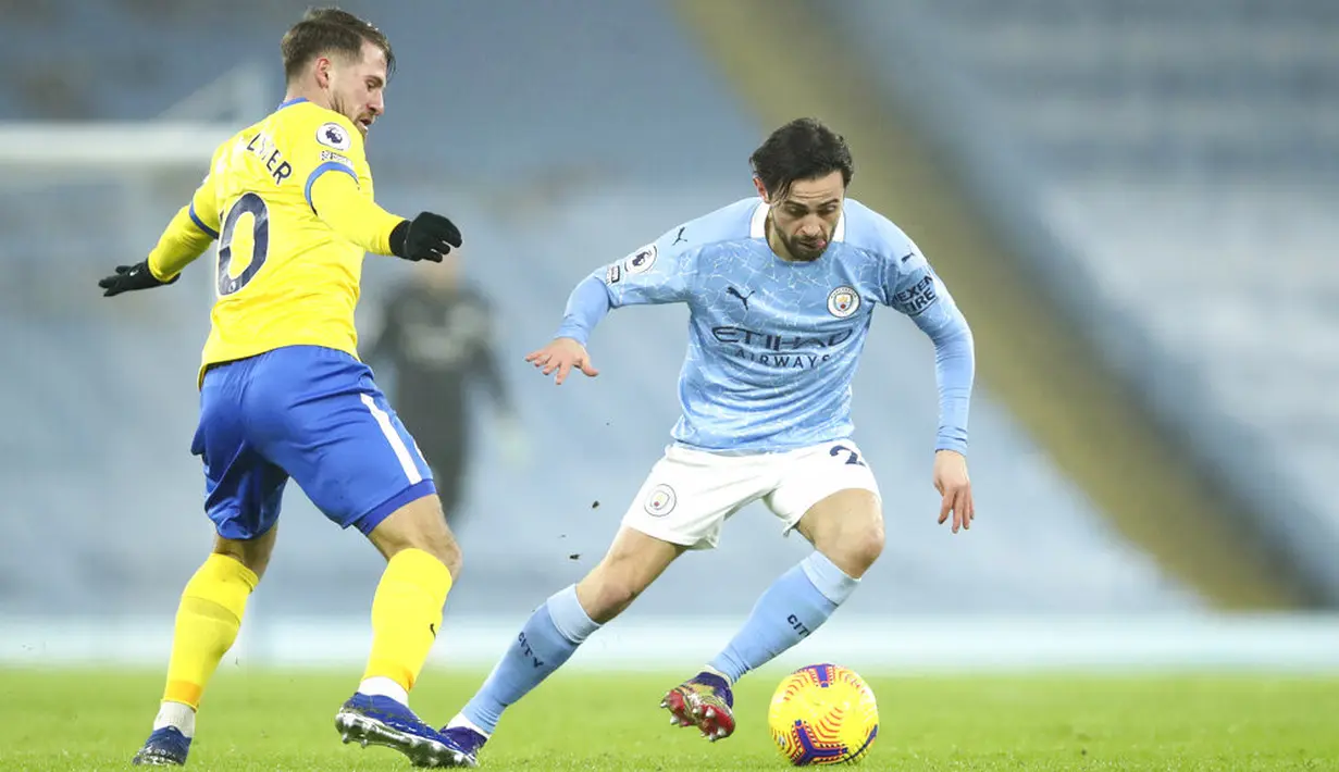 Pemain Brighton and Hove Albion Alexis Mac Allister (kiri) berebut bola dengan pemain Manchester City Bernardo Silva pada pertandingan Liga Inggris di Etihad Stadium, Manchester, Inggris, Rabu (13/1/2021). Manchester City menang 1.0. (Clive Brunskill/Pool via AP)