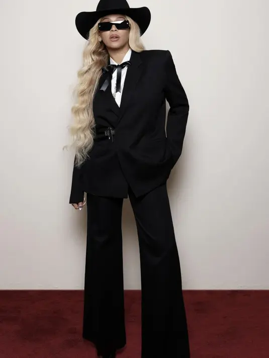 Memaksimalkan gayanya, Blazer dengan potongan tailored dan celana wide leg, serta aksen topi koboi kembali hadirkan twist yang begitu stylish. [Foto: Instagram/ Beyonce]