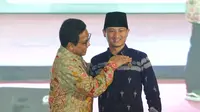 Menteri Desa, Pembangunan Daerah Tertinggal dan Transmigrasi Republik Indonesia, Dr. Drs. Abdul Halim Iskandar, M.Pd., menyerahkan penghargaan kepada Bupati Trenggalek, Mochamad Nur Arifin di Graha Sabha Pramana, Universitas Gadjah Mada, Yogyakarta.