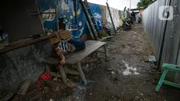 Seorang pria tidur di kawasan Kampung Akuarium, Jakarta, Selasa (17/2/2021). Badan Pusat Statistik (BPS) mengungkapkan jumlah penduduk miskin Indonesia pada September 2020 mencapai 27,55 juta orang, meningkat 2,76 juta dibandingkan posisi September 2019. (Liputan6.com/Faizal Fanani)