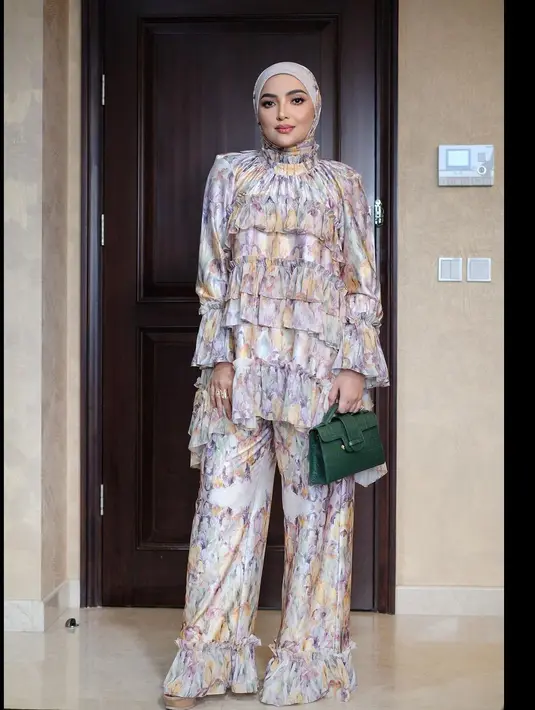 Outfit bukber penuh pesona dari Ashanty. Ashanty memang tak pernah tampil tanggung-tanggung. Di sini, Ashanty mengenakan set atasan dan bawahan serasi bercorak abstrak dengan detail ruffles yang manis, dipadukan hijab cokelat muda yang serasi. [Foto: Instagram/loritayoung_mua]