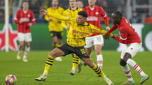 Pemain Borussia Dortmund, Jadon Sancho (kiri) berebut bola dengan pemain PSV Eindhoven, Jordan Teze pada laga leg kedua 16 besar Liga Champions 2023/2024 di Signal Iduna Stadium, Dortmund, Jerman, Kamis (14/03/2024) dini hari WIB. (AP Photo/Martin Meissner)