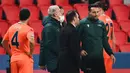 Pelatih Istanbul Basaksehir, Okan Buruk (kedua dari kanan), berbicara dengan asisten wasit ke-4, Sebastian Coltescu usai dihentikannya laga lanjutan Liga Champions Grup H melawan Paris Saint-Germain di Parc des Princes Stadium, Selasa (8/12/2020). (AFP/Franck Fife)