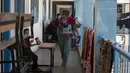 <p>Seorang wanita berjalan saat berlindung di sekolah yang dikelola oleh PBB setelah melarikan diri dari serangan rudal hebat Israel di pinggiran Kota Gaza, Rabu (19/5/2021). Mereka terpaksa meninggalkan rumah di tengah semakin gencarnya serangan udara dari militer Israel. (AP Photo/Khalil Hamra)</p>