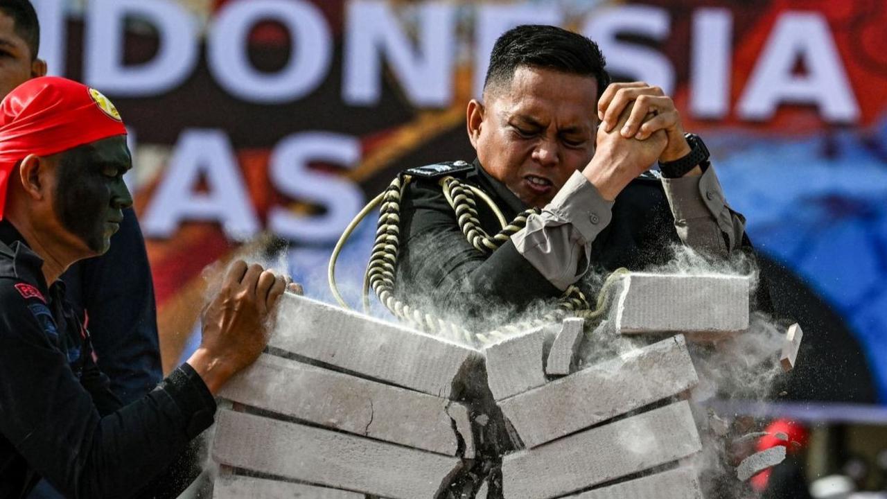 Pertunjukan mematahkan balok beton oleh anggota polisi tersebut menjadi simbol kekuatan dan ketangguhan Polri dalam menjaga keamanan dan ketertiban. Foto: CHAIDEER MAHYUDDIN / AFP<br>