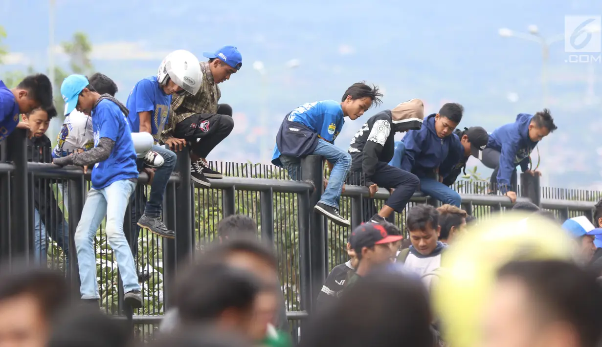 Suporter Persib memanjat pagar Stadion Gelora Bandung Lautan Api, Bandung, Selasa (16/1). Persib akan menjamu Sriwijaya FC pada laga perdana Piala Presiden 2018 yang akan dibuka oleh Presiden Joko Widodo. (Liputan6.com/Helmi Fithriansyah)