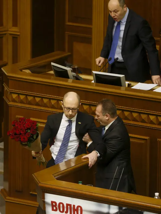 Seorang anggota parlemen bernama Oleg Barna tampak menyeret PM Arseny Yatsenyuk (kanan) dari podium saat membacakan laporan tahunan kinerja Pemerintah Ukraina di Majelis Tinggi Parlemen Ukraina, 11 Desember 2015. (REUTERS/Valentyn Ogirenko)